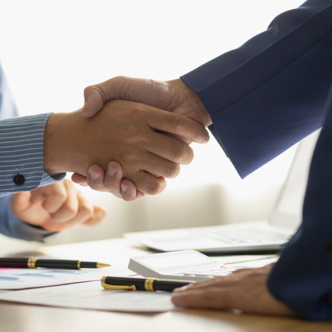 Businessmen and investors shake hands as symbol of joint venture after discussing, consulting and making contract to invest in business together. business people shaking hands as symbol of cooperation